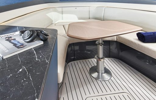 Princess R35 interior dinette area, with U shaped sofa in the bow, fixed table and surface on port side