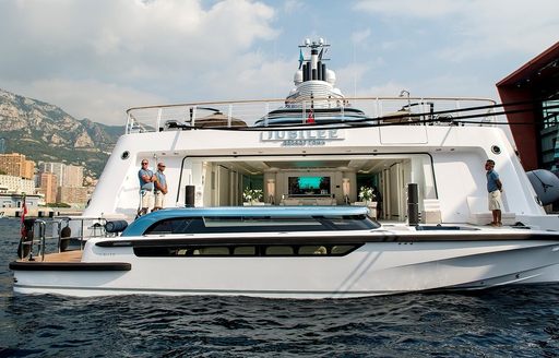 Tender boat in front of mothership with two people on main yacht