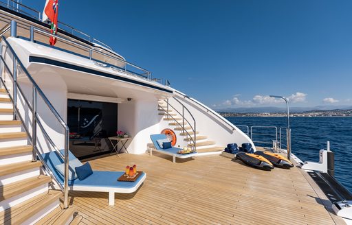 Beach club area onboard superyacht SOARING, sunloungers and water toys on swim platform, surrounded by the sea.