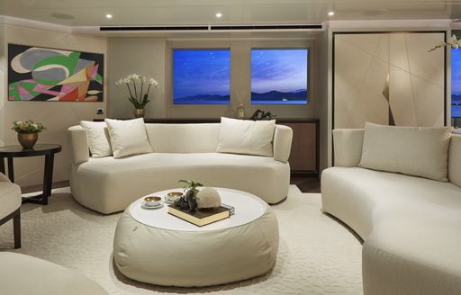 Main lounge area onboard Heesen 'Project Triton', curved sofas facing inwards around low down coffee table