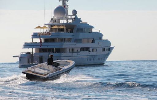 Chase boat on sea with superyacht in background