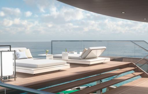 Sun loungers on wooden sundeck of Estrade superyacht with blue sky and sea in the background