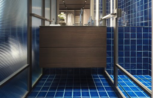 The VIP bathroom onboard ALMAX features bright blue tiles and warm woods