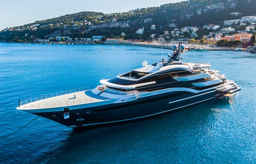 Oceanco yacht DAR aerial view over port bow and along side profile, still waters, bright day, land in background