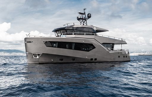 ROCK X by Evadne Yachts shown from water level towards port bow and port side profile, on bright but cloudy day in moderate sea