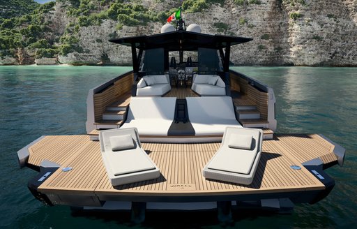 Extendable swim platform onboard Wally WHY100. Yacht in the sea facing large cliffs.