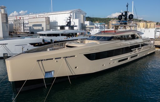 Motor yacht Rilassata at anchor with construction sheds in the background