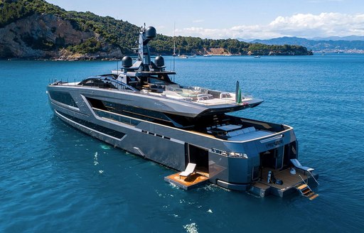 Aft view of superyacht PANAM, transom and port side balcony folded down with sun loungers on top. 