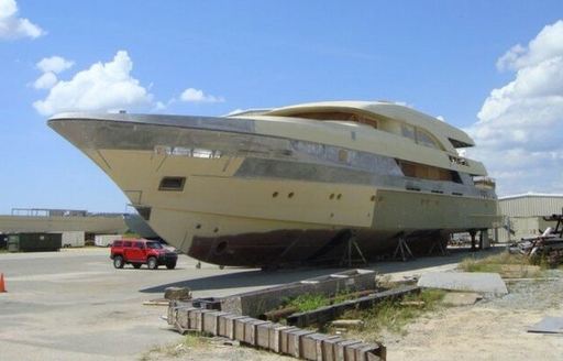 Forward view overlooking the bow of incomplete Trinity T056 hull, sat on tarmac after auction.