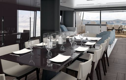 Dining area onboard Pershing GTX116. Long black table surrounded by chairs, aft deck visible in background.