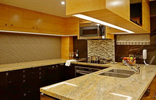 Galley on yacht with marble  top and wooden detailing