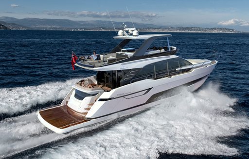 Fairline Squadron 68 running shot, starboard quarter deck and side profile, in smooth sea, on bright day, land in background