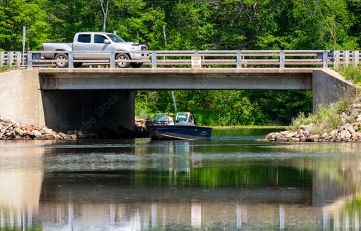 air draft boat passing under bridge