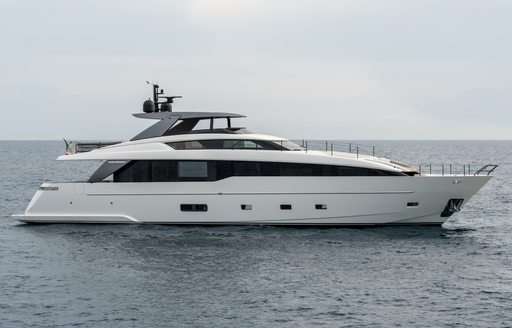 A starboard-side view of the Sanlorenzo SL86A sporting a white hull and extensive black glazing, floating in a calm grey sea