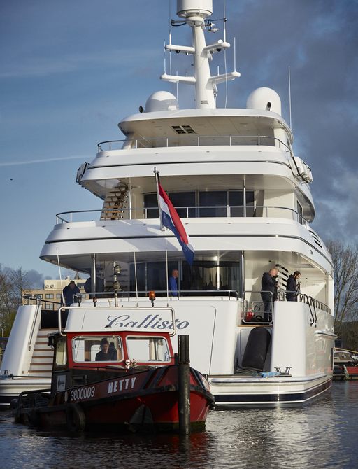 Aft view of Feadship CALLISTO superyacht, Feadship team members onboard looking out on multiple decks.