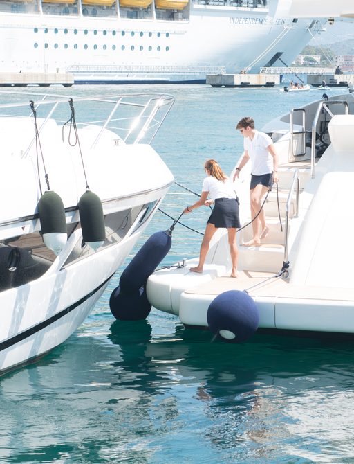 Yacht crew handling fenders and lines for superyacht mooring activity