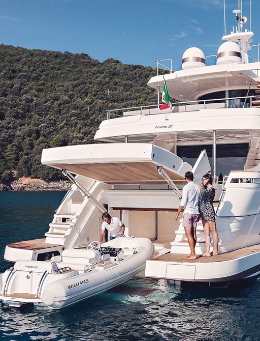 Tender at back of large superyacht with three people watching