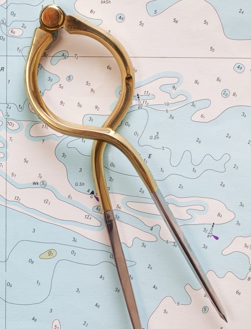 close up of dividers on nautical chart note depth contours