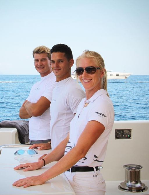 Three smartly dressed superyacht crew onboard motor yacht