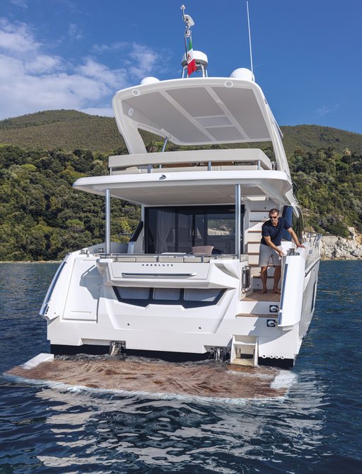 Aft view of Absolute 50Fly, swim platform submerged and guest overlooking from main deck aft