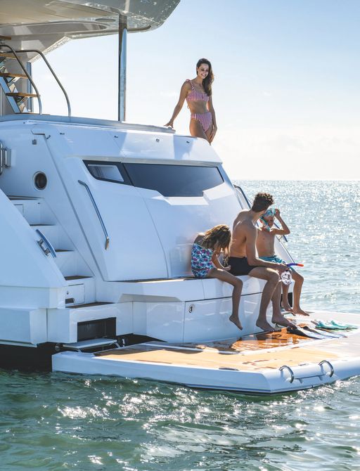 Sunseeker Manhattan 68 for sale at Fort Lauderdale International Boat Show, image shows family on bathing platform with deck slightly lowered into the water