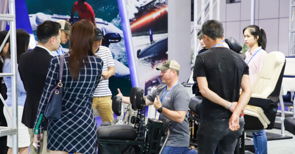 Exhibitor stand at China International Boat Show. Demonstrator showing off range of chairs to interested visitors.