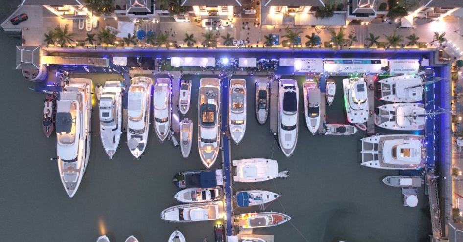 Aerial view of Thailand Yacht Show, looking directly down on to selection of motor yachts berthed in marina.