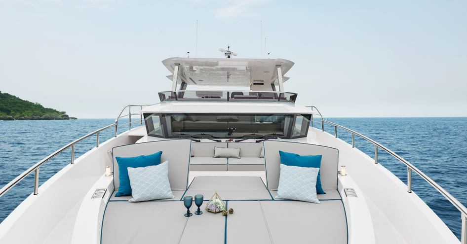 Bow onboard Horizon FD75, central sunpads under the pilothouse window, surrounded by sea