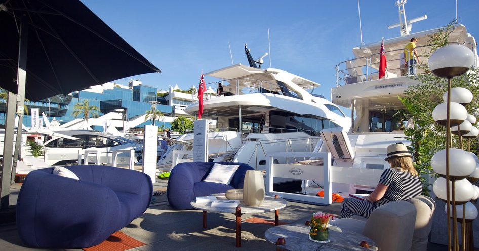 Aft view of Sunseeker motoryachts lined up at Cannes Yachting Festival, with small lounge area in foreground