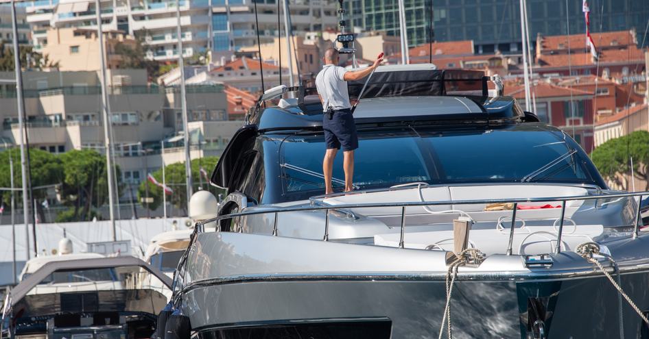 superyacht deckhand washing yacht windows