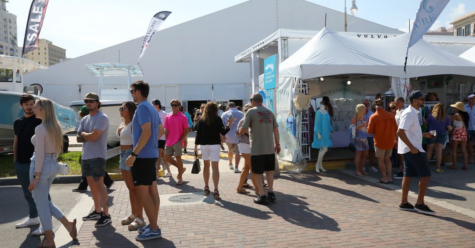 Multiple exhibitor stands at the Palm Beach International Boat Show with many visitors walking around