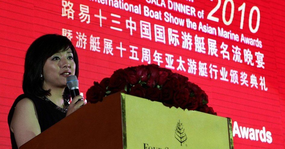 Female speaker with microphone on stage at Asian Marine & Boating Awards 2010.