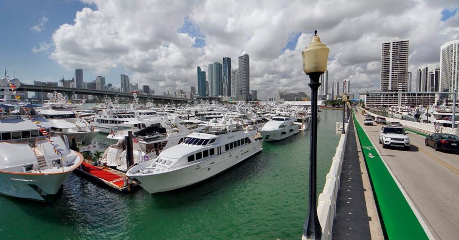 Display of berthed motor yachts at Miami Yacht Show, running alongside causeway.