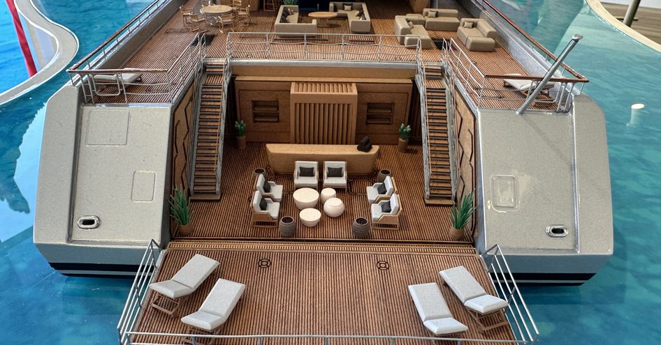 Aft view of a scale model of superyacht DRAGONFLY, beach club with sun loungers and exterior lounge area