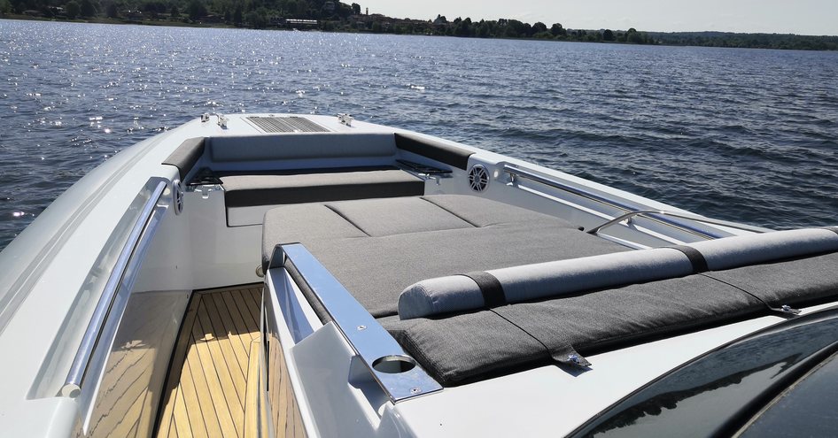 Long view of Tecnorib Pirelli 42 foredeck, overlooking central sunpads and surrounded by sea with island in foreground.