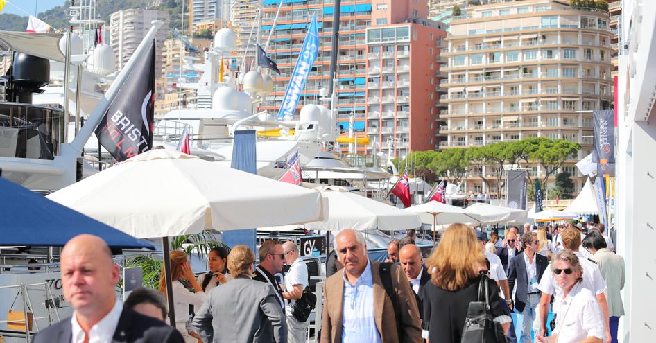 Visitors walking among exhibitors at the Monaco Yacht Show.