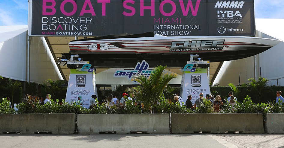 Herald Plaza in Miami during the Miami International Boat Show, speed boat on display in front of show banner.