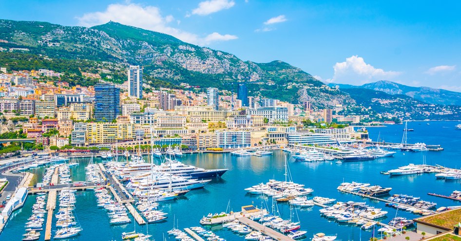 Overview of Port Hercule, looking over many motor yachts and sailing boats moored in the marina.