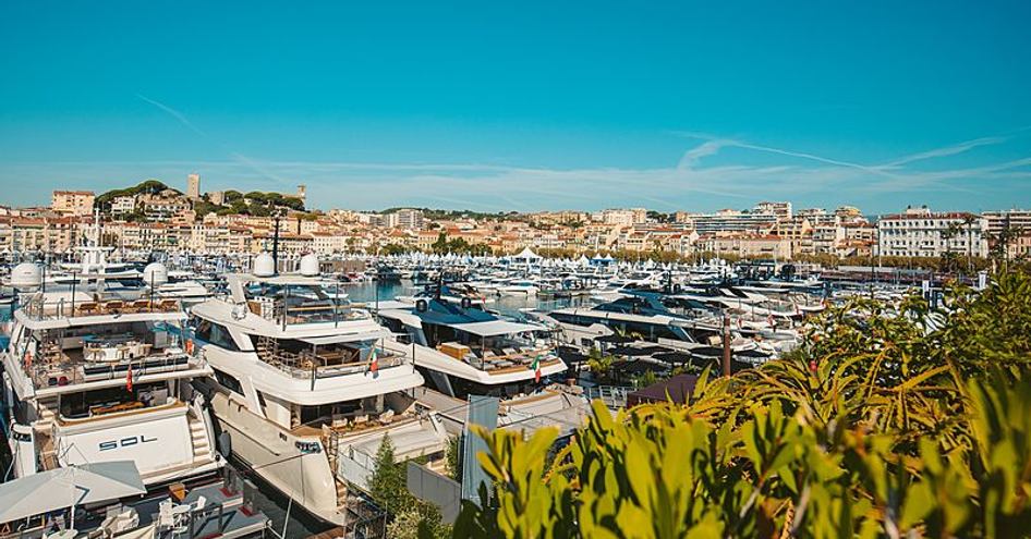 Anchored motoryachts at Vieux Port in Cannes, surrounded by clear skies and the town of Cannes