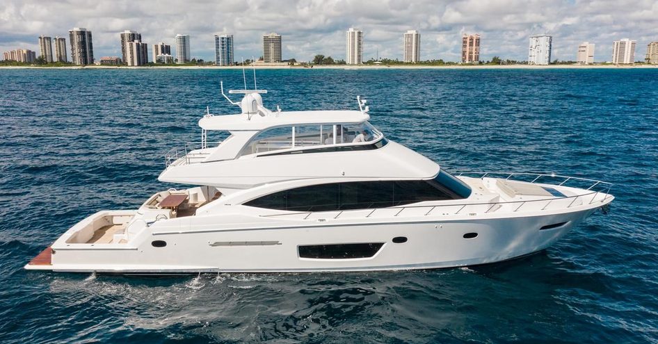 Side view of Viking 82 MY underway, surrounded by sea and cosmopolitan skyscrapers in background