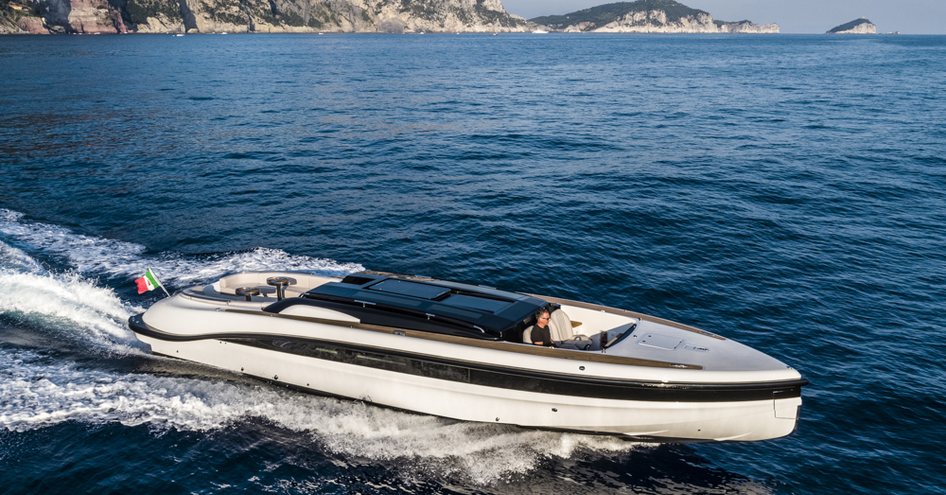 Wooden Boats WB14 limousine tender on sea with hills in the background