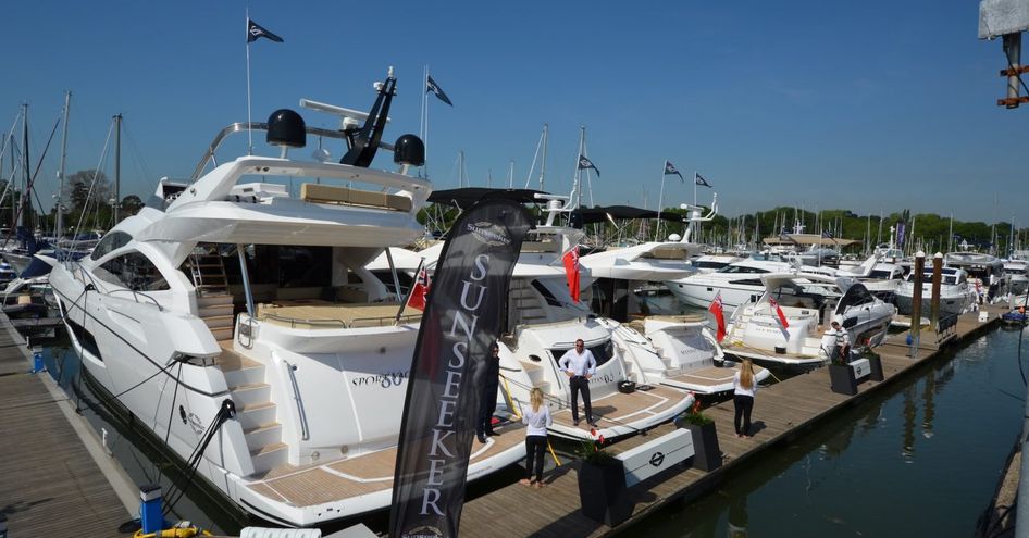 Sunseeker yachts berthed at British Motor Yacht Show, aft view of yachts with Sunseeker flag.