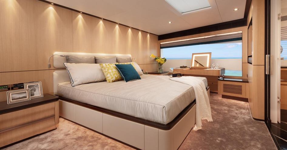 cream double bed, beige carpets and cream wall panels in the master suite on board the FD87 Skyline yacht model