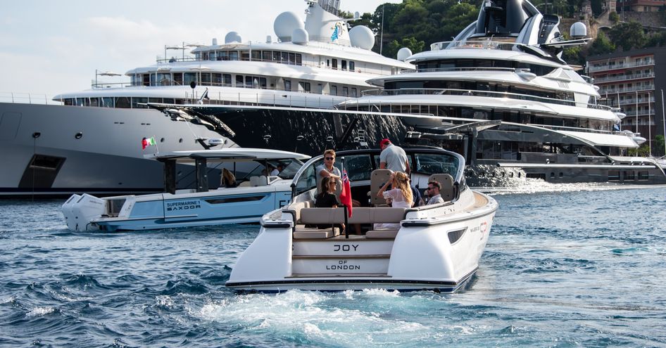 Superyachts berthed in Port Hercule with a tender in the foreground