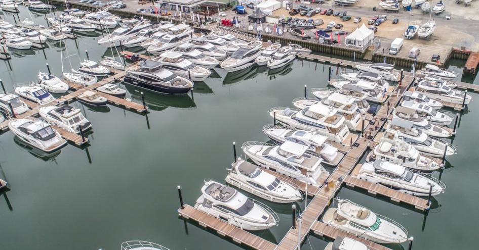 Overview of Swanwick marina in Southampton. Multiple motor yachts for sale moored along the dock.