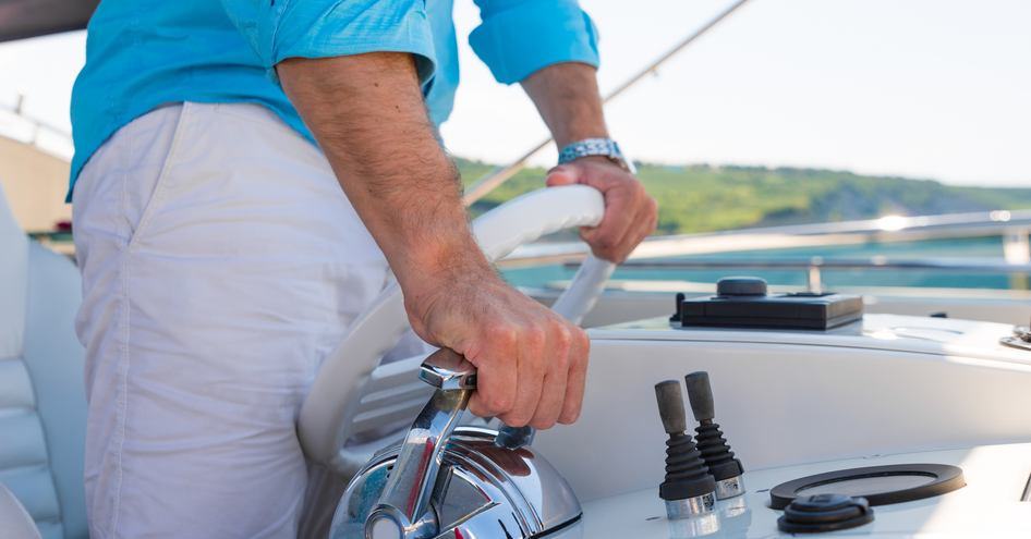 man driving a motor yacht 