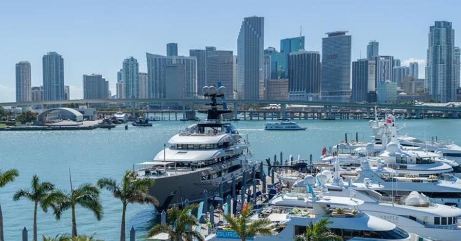 Superyachts moored at Yacht Haven Grande Miami at Island Gardens marina, surrounded by sea and Miami skyline