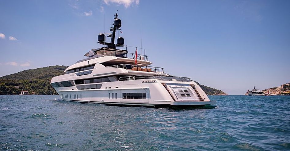 Rear view of Sanlorenzo Lady Lena underway, surrounded by sea and elevated terrain in the background