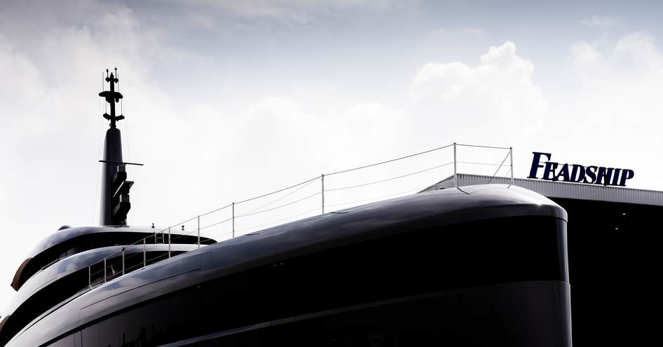 Close up view looking over the top of Feadship Project 710's bow, with Feadship sign in the background.