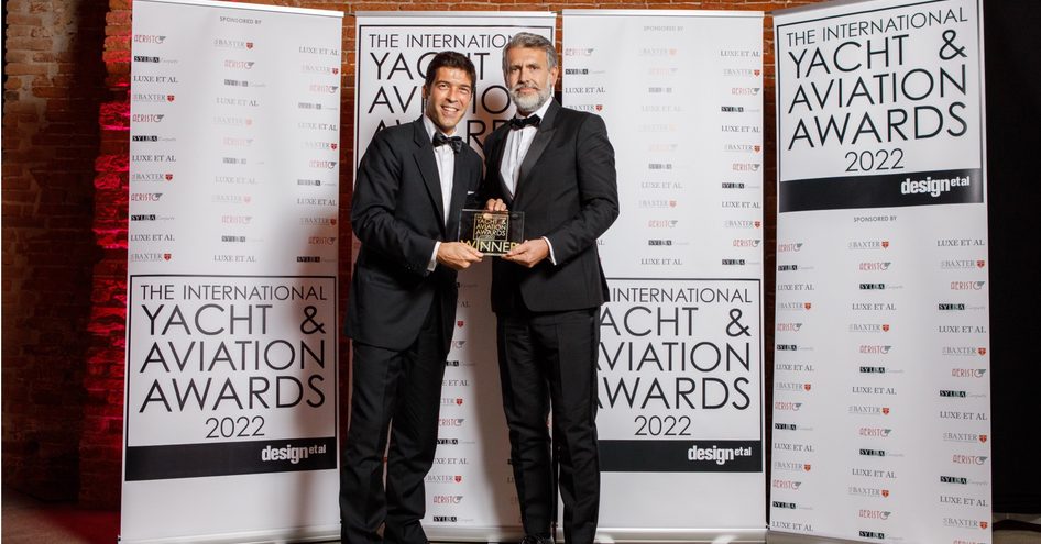 Landscape shot of International Yacht And Aviation Awards winners in front of branded posters.